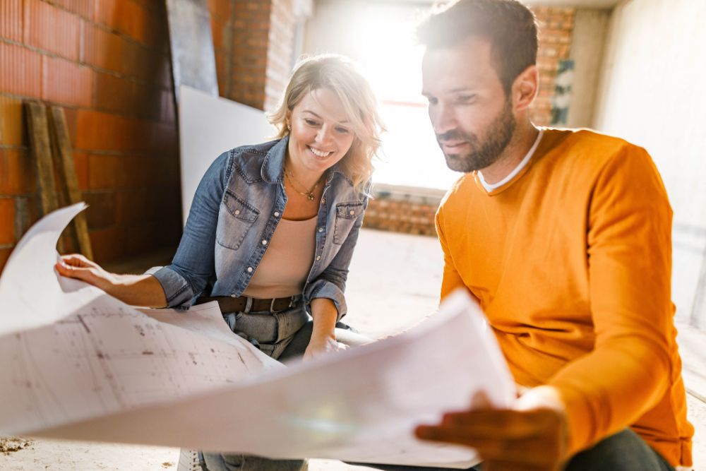 Happy couple analyzing floor plans