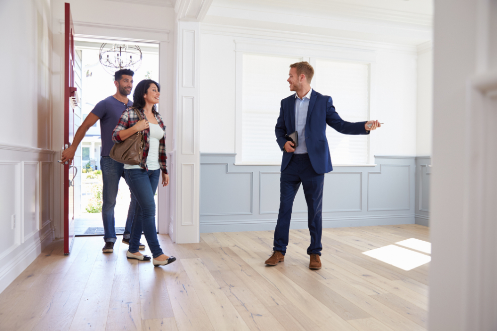 real estate showing new home to his client couple
