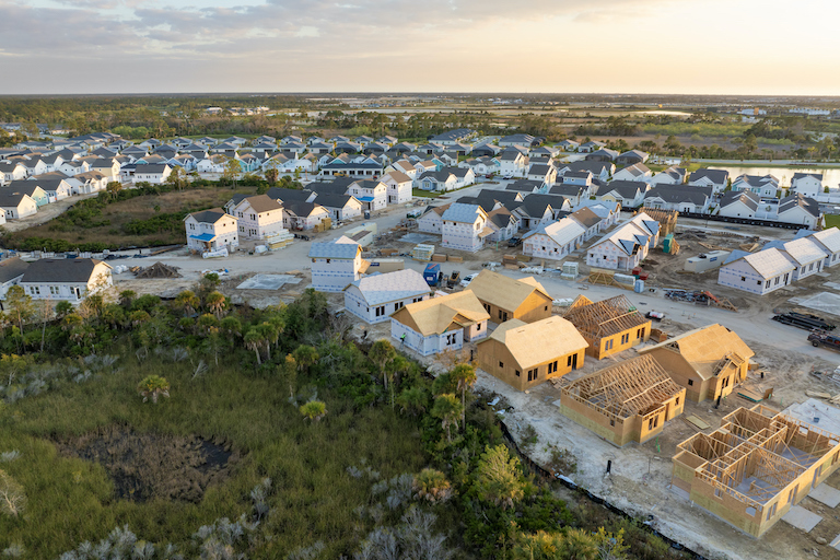 Wooden houses under construction in new developing suburban area. Development of residential housing in American suburbs. Real estate market in the USA.